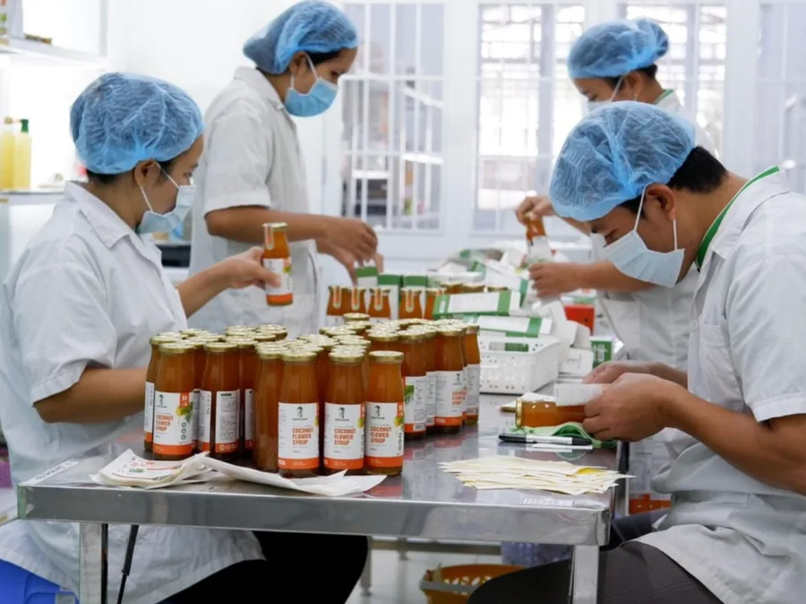 Công nhân đóng chai mật hoa dừa trong xưởng